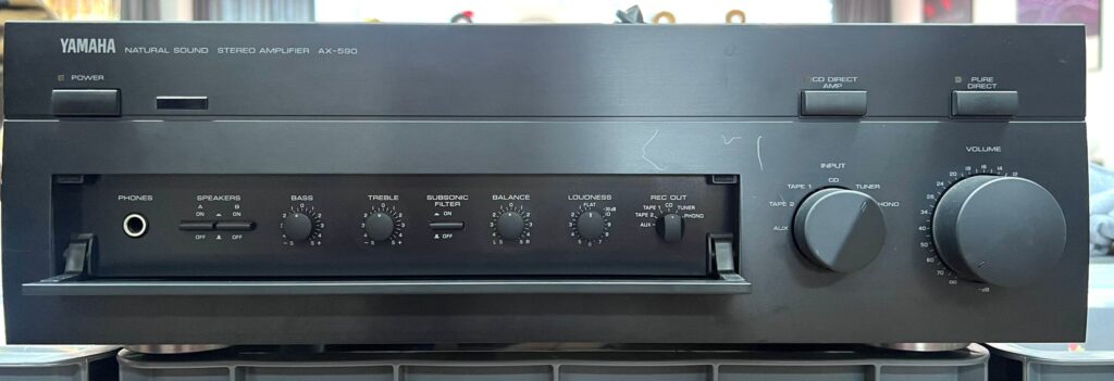 AX - 590 Yamaha
Allgemein

Hersteller: Yamaha
Modell: AX-590
Baujahre: 1995 – 1997
Hergestellt in: Malaysia
Farben: Schwarz, Titan
Fernbedienung: ja
Leistungsaufnahme: 210 W max.
Abmessungen: 435 x 146 x 389 mm (BxHxT)
Gewicht: 10,4 kg
Neupreis ca.: 720 DM, 369 € (umgerechnet)

Anschlüsse

Anzahl der Eingänge:
Phono MM/MC 2,5 mV / 47 kOhm, 160 µV / 220 Ohm
CD, Tuner, AUX, 2 x Tape 150 mV / 47 kOhm
Main-In 1 V / 10 kOhm
Anzahl der Ausgänge:
2 x Lautsprecher
2 x Rec-Out 150 mV / 470 Ohm
Pre-Out 1 V /1 kOhm
Kopfhörer 0,33 V / 680 Ohm

Technische Daten

Dauerleistung (bei Klirrfaktor)
8 Ohm: 2 x 100 Watt bei 0,015 %
4 Ohm: 2 x 150 Watt (DIN)
Dynamikleistung
8 Ohm: 2 x 140 Watt
4 Ohm: 2 x 220 Watt
Gesamtklirrfaktor: 0,005 %
Dämpfungsfaktor: 320
Frequenzgang: 10–50.000 Hz
Signalrauschabstand: 110 dB
Stereokanaltrennung: 65 dB
Klangregelung:
Bass: ± 10 dB bei 20 Hz
Höhen: ± 10 dB bei 20.000 Hz
Loudness: regelbar
High Filter: nein
Low Filter (Subsonic): 15 Hz / 18 dB, schaltbar
Mute: nein
Direct/Line-Straight: CD-Direct und Pure-Direct

Besondere Ausstattungen

Record-Selektor
Sekundäre Bedienelemente unter Abdeckklappe
